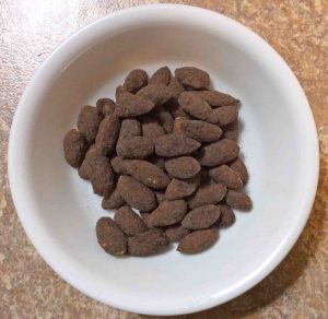 Picture of a white bowl of Planters Cocoa Almonds. 